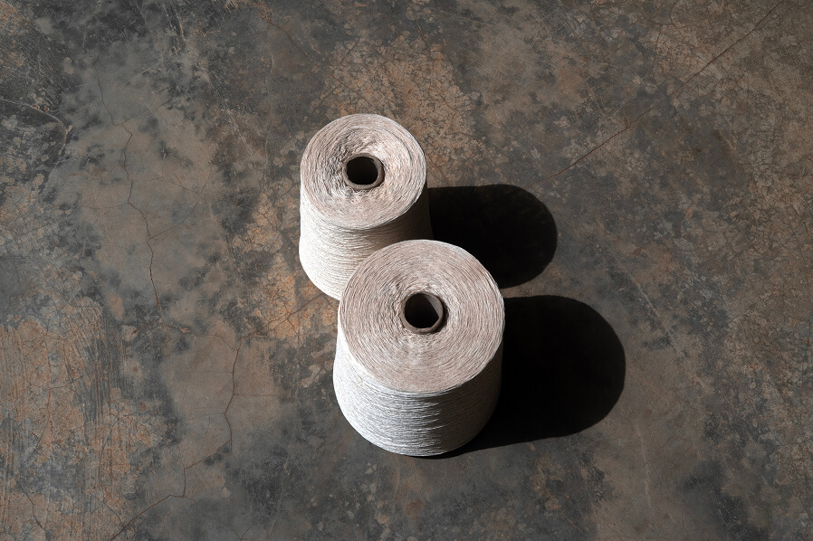 Fibre is spun into spools, establishing the consistent tension required for the loom.